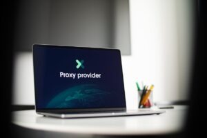 Laptop displaying "Proxy provider" logo on desktop, set on a modern desk with stationery in the background.